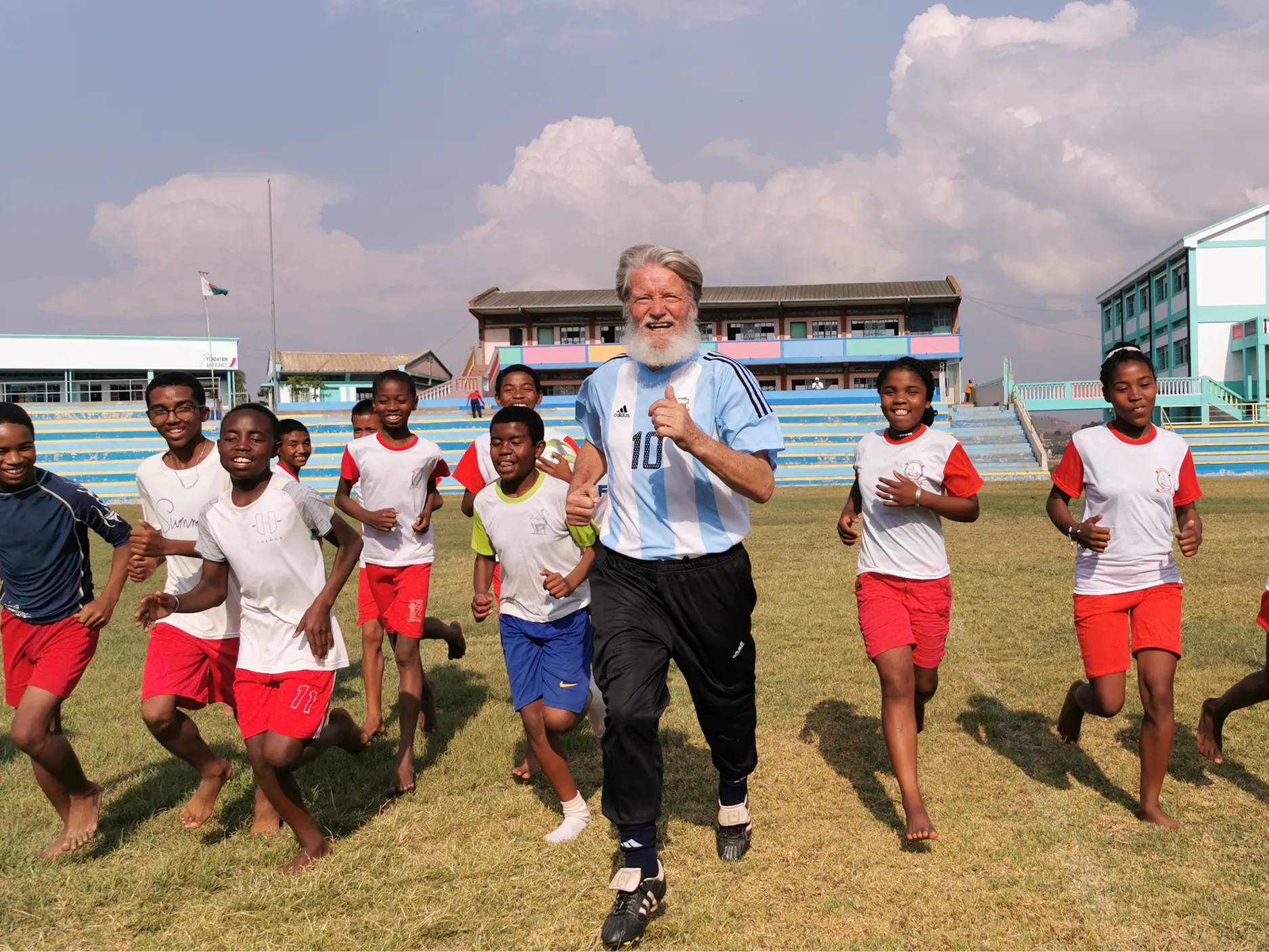 Peter Opeka, ki z otroci teče na nogometnem igrišču
